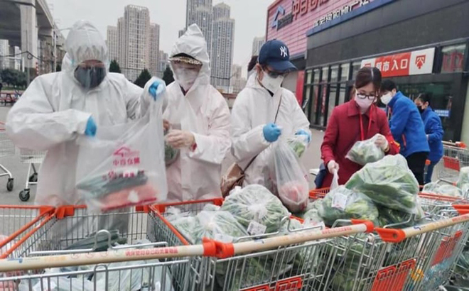 Tình nguyện viên hỗ trợ phân loại và đóng gói hàng tạp hóa ở một siêu thị tại Vũ Hán